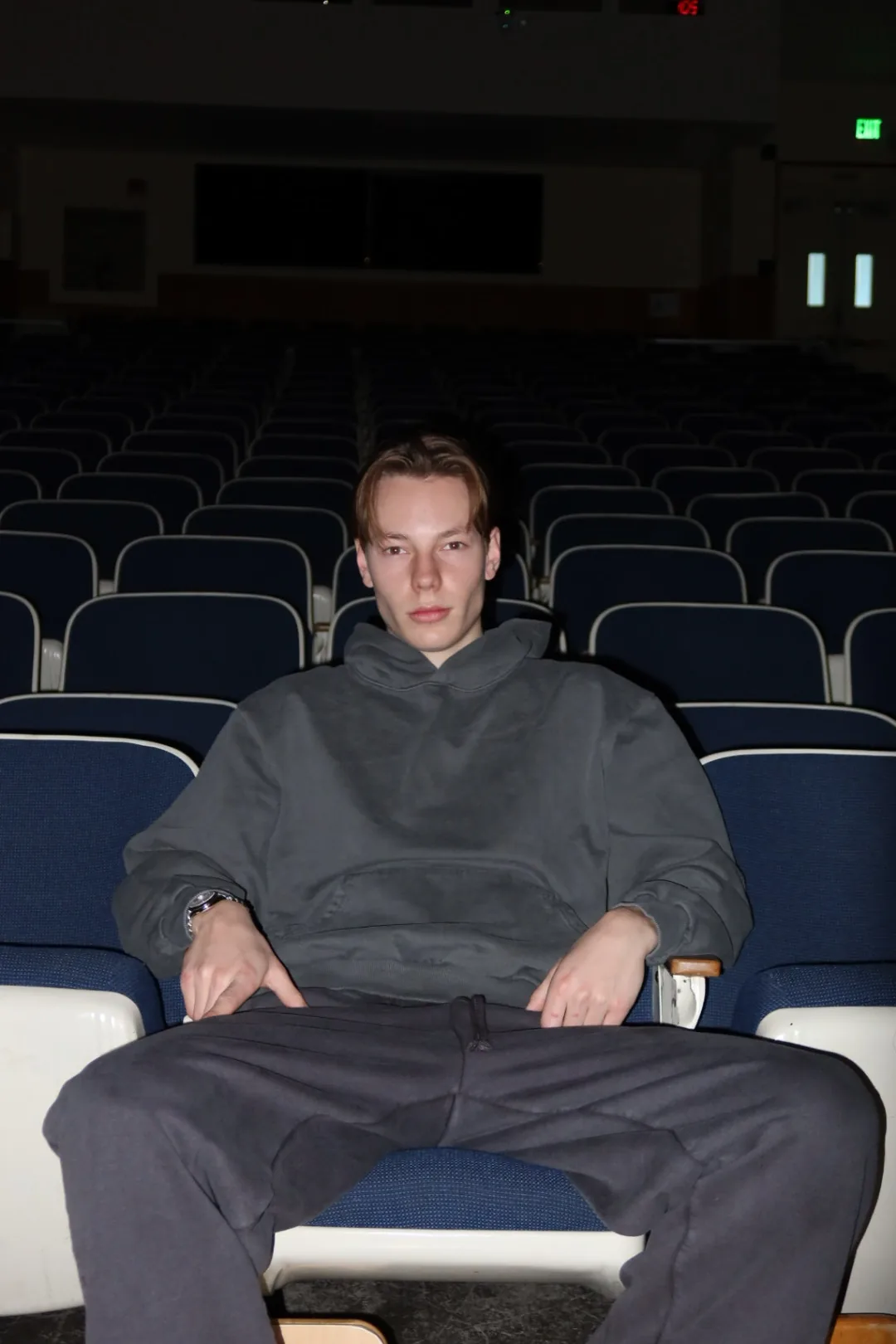 Coordinated grey hoodie and sweatpants styled in an auditorium