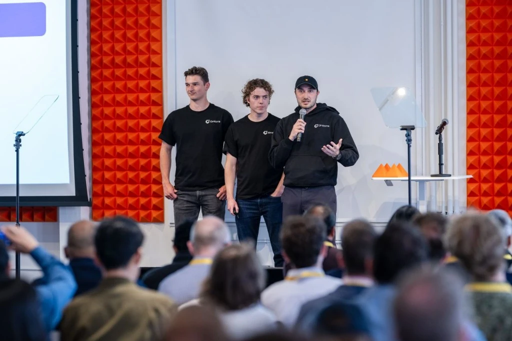 Ontora's founding team presenting at their Y Combinator batch in black Ontora tees and hoodie